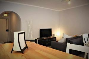 a living room with a couch and a television at AlgarveSand Carvoeiro in Carvoeiro