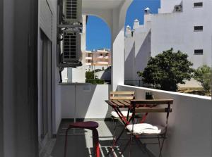 a balcony with two chairs and a table on a building at AlgarveSand Carvoeiro in Carvoeiro