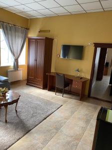 ein Wohnzimmer mit einem Schreibtisch und einem TV in der Unterkunft Hotel Gostynnyi Dvir in Bucha
