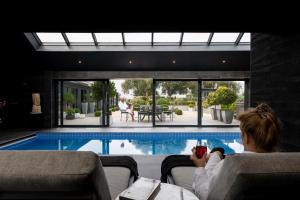 a woman sitting in a chair next to a swimming pool at Black Barn Spa Swim & Stay in Great Yarmouth