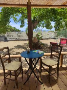 - une table et deux chaises sur une terrasse couverte avec une table dans l'établissement Philoxenia, maison et table d'hôtes, à La Saline les Bains
