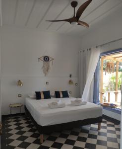 1 dormitorio con 1 cama y ventilador de techo en Philoxenia, maison et table d'hôtes en La Saline les Bains