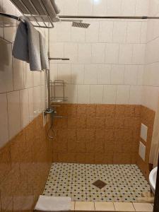 La salle de bains est pourvue d'une douche et de carrelage. dans l'établissement Hotel Gostynnyi Dvir, à Bucha