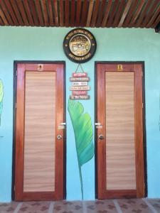 two doors in a room with a sign on the wall at Mountaindew Garden and Pool in Roxas