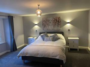 - une chambre avec un grand lit et 2 tables de chevet dans l'établissement Immaculate 2-Bed Apartment above Village Pub, à Buxton