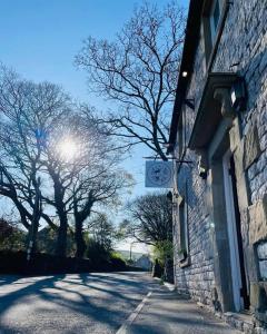 a building with a clock on the side of a street at Cosy Apartment above Village Pub in Buxton