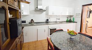 a kitchen with a table with a bowl of fruit on it at Apartamentos Caleiro 4P - Vilanova de Arousa in Villanueva de Arosa