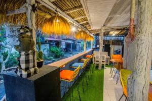a restaurant with a bar with chairs and tables at Naturale Guest House in Nusa Lembongan
