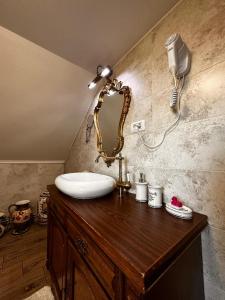 a bathroom with a sink and a mirror on a wooden counter at Cabana Rustic Bran in Bran