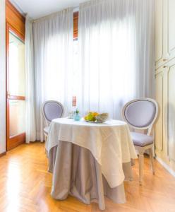 une table dans une pièce avec un chiffon de table blanc dans l'établissement B&B San Benedetto, à Bergame
