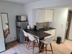 a kitchen with a black counter and white appliances at Studio zone piétonne à Saverne in Saverne