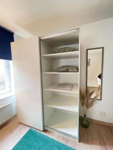 a white closet with a mirror in a room at Studio zone piétonne à Saverne in Saverne