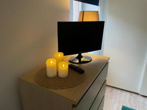 a desk with a computer monitor and two candles on it at Studio zone piétonne à Saverne in Saverne