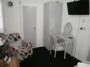 Habitación con escritorio, silla y espejo. en The Withnell Hotel en Blackpool