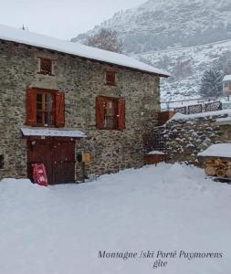 una casa in pietra con un garage nella neve di Montagne Ski Porté Puymorens GÎTE a Porté-Puymorens