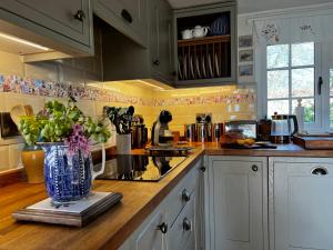 a kitchen with a vase of flowers on a counter at Elm Cottage in Northallerton