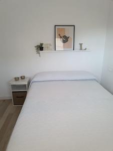 ベニドルムにあるVista Bahia Benidormの白いベッドルーム(テーブル付)の白いベッド1台