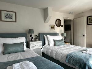 two beds sitting next to each other in a bedroom at Elm Cottage in Northallerton