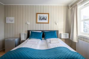 1 dormitorio con 1 cama grande con almohadas azules en Mo Gjestegård, en Mo i Rana