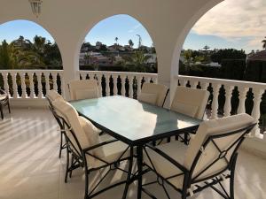 a dining room with a glass table and chairs on a balcony at Casa Sara - Private Villa with Private Pool in Ciudad Quesada
