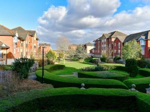 a garden with green bushes and houses in the background at Pass the Keys Cosy 2 Bed Apartment with Parking in Cardiff