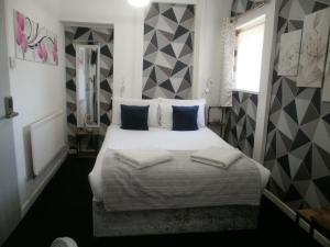 a bedroom with a large white bed with pillows at The Withnell Hotel in Blackpool