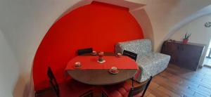 une chambre rouge avec une table et une chaise dans l'établissement Partenope Magica, à Naples