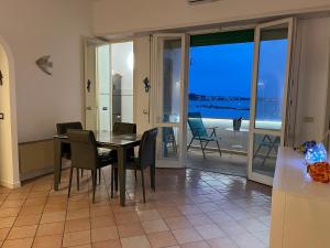 a dining room with a table and chairs and a balcony at Il cavalluccio in Anzio