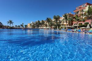 a large swimming pool in a resort with palm trees at Bahia Principe Sunlight Costa Adeje - All Inclusive in Adeje