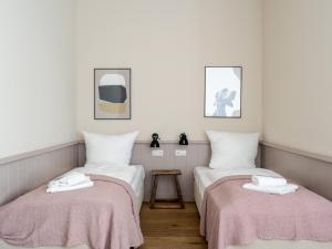 twee bedden in een kamer met witte muren en roze dekens bij Schoenhouse Avenue - Digital Access in Berlijn