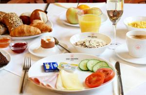 維也納的住宿－蒂勒科羅恩維恩城市酒店，餐桌,带食物盘和酒杯