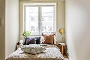 a bedroom with a bed with pillows and a window at Magnificent Modern Apartment — Gamle Oslo/ Bjørvika in Oslo