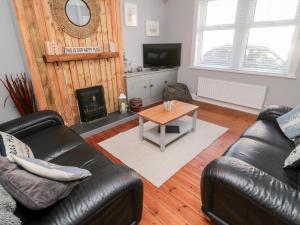 Sala de estar con 2 sofás de cuero y mesa de centro en 4 Percy Street en Morpeth