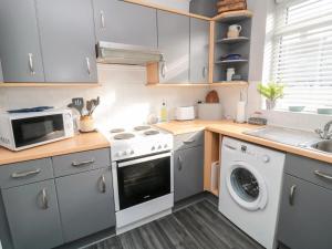 cocina con lavadora y microondas en 4 Percy Street en Morpeth