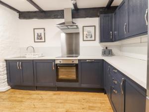 a kitchen with navy blue cabinets and a sink at The Eller Beck in Skipton