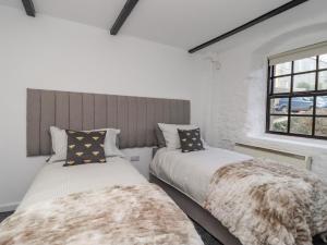 a bedroom with two beds and a window at The Eller Beck in Skipton