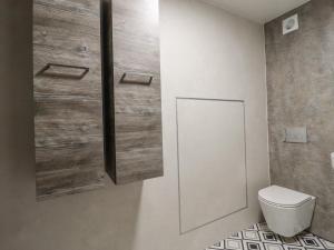a bathroom with a toilet and a wooden wall at The Eller Beck in Skipton +24 photos