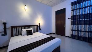 1 dormitorio con 1 cama con manta blanca y negra en Ali Adi Eco Lodge, en Sigiriya