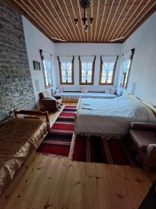 ein Schlafzimmer mit einem großen Bett in einem Zimmer mit Fenstern in der Unterkunft Traditional GuestHouse Permet in Përmet