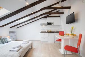 a kitchen and living room with white cabinets and a table at Central apartments in Pula
