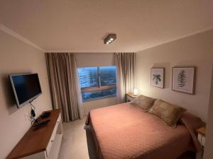 1 dormitorio con 1 cama, TV y ventana en Ocean Drive, 2 dorm y amenities, en Punta del Este