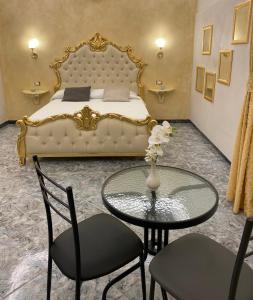 a bedroom with a bed and a table and chairs at Suite Incentro Salerno in Salerno