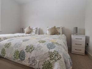 a bedroom with a bed with a comforter on it at Castle Cottage in Hythe