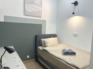 una camera da letto con un letto con una lampada e delle scarpe sopra di Lovely MuJi @SS15 (Inti College) a Subang Jaya Altre 16 foto