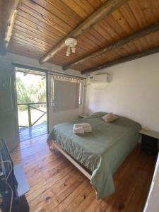 1 dormitorio con cama verde y suelo de madera en El Limbo Posada en Tigre