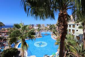 a view of a pool at a resort with palm trees at Bahia Principe Sunlight Tenerife - All Inclusive in Adeje