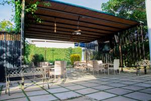 a pavilion with chairs and a table and a television at Distinction Gardens in Siaya