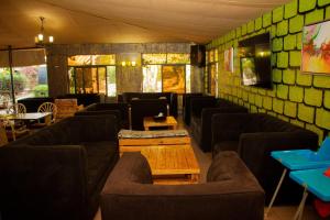 a room with couches and tables in a restaurant at Distinction Gardens in Siaya