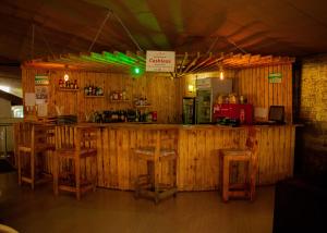 a bar in a restaurant with wooden walls and stools at Distinction Gardens in Siaya