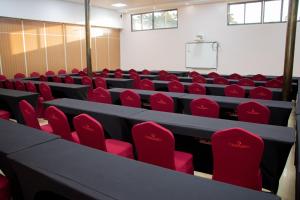 an empty lecture hall with red chairs and a table at Distinction Gardens in Siaya